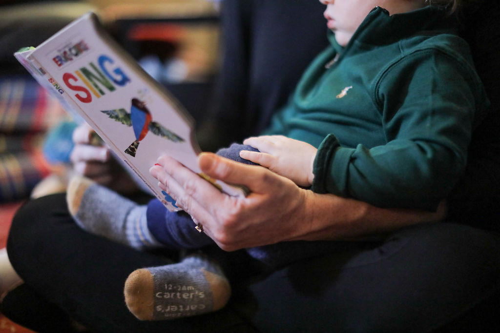 Cormac Hanson listens to his mother, Casey Hanson, read a book